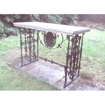 An unusual stone and wrought iron table with cast iron medallion by Morgan, Macaulay and Wade